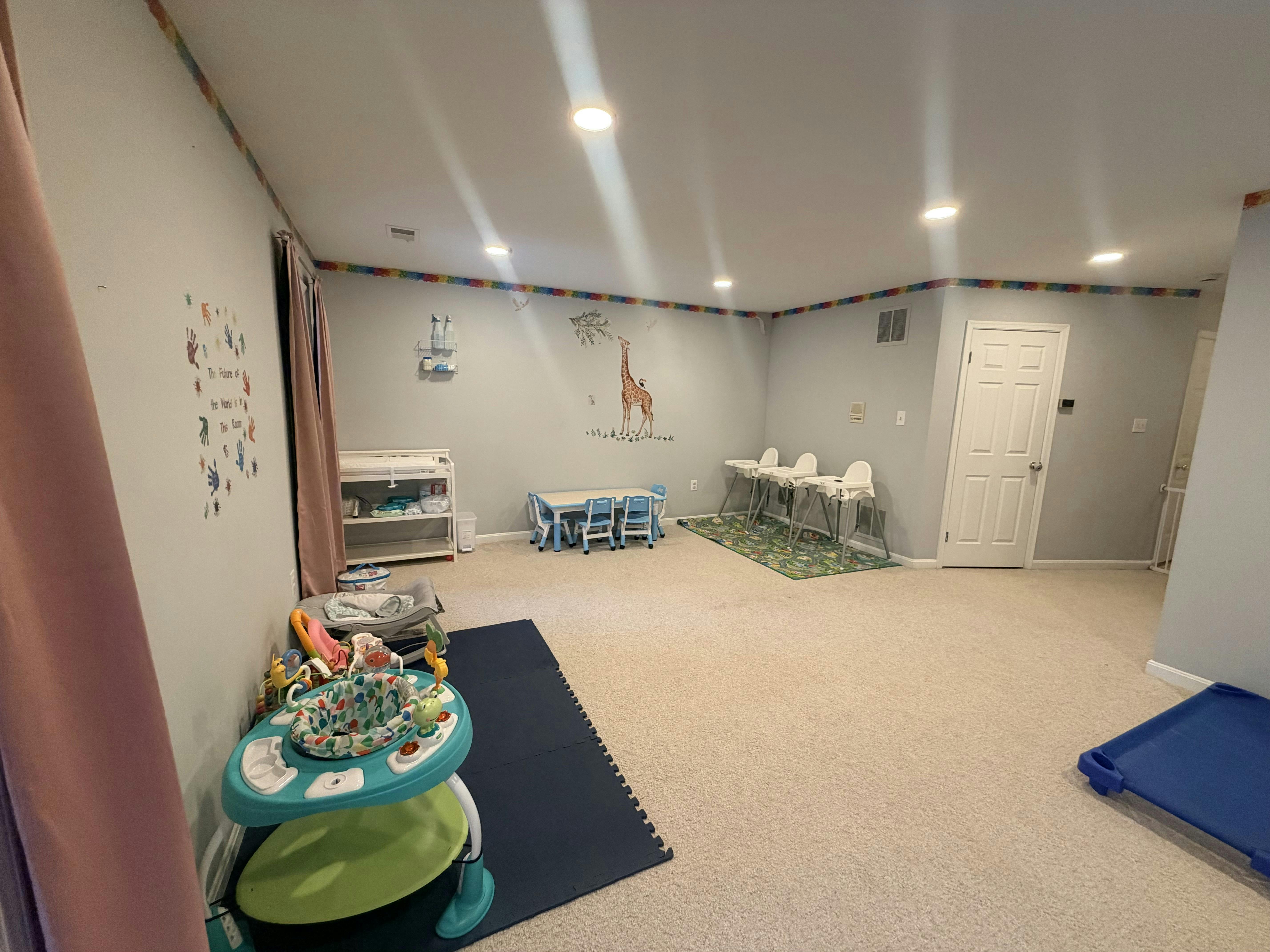 Baby changing table, small table and chairs, and high chairs in a room