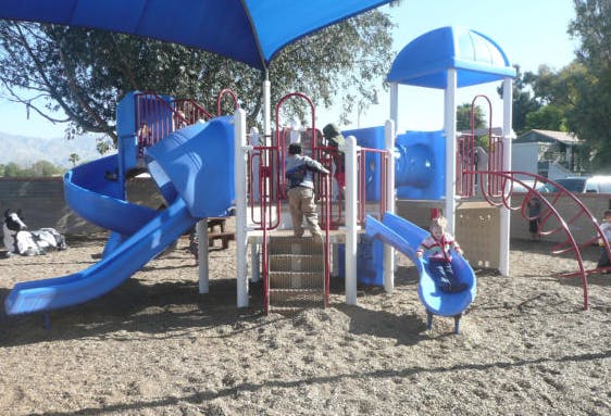 Child on a blue and red playground structure