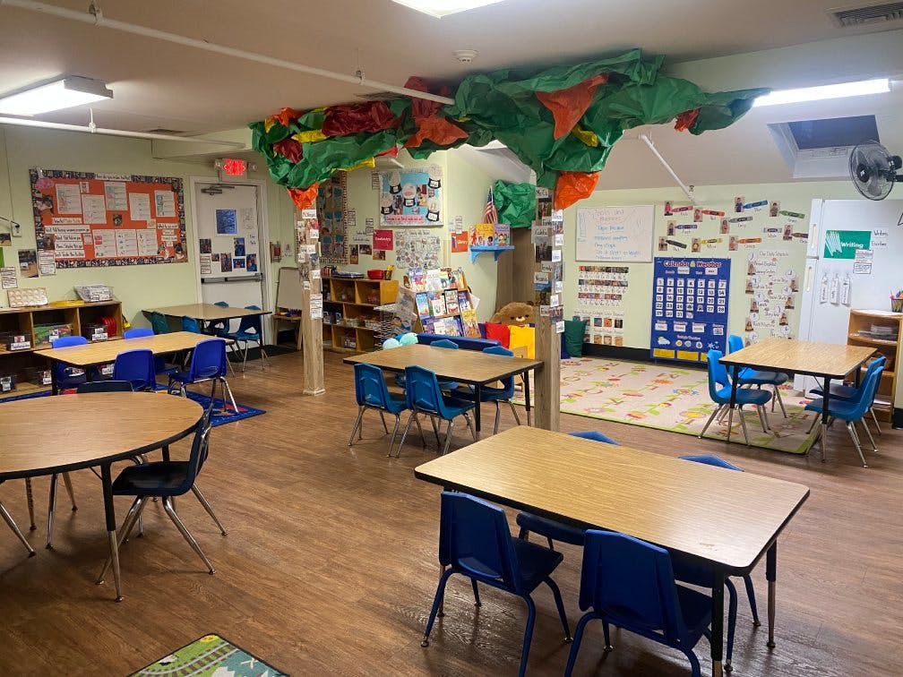 Classroom with small tables and chairs, decorated walls and ceiling