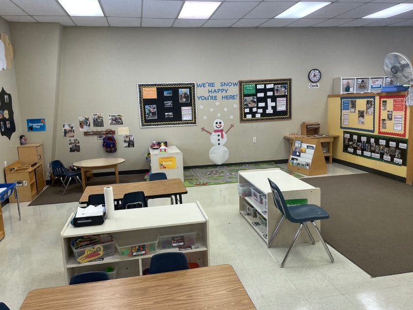 Empty classroom with tables, chairs, and winter-themed wall decorations