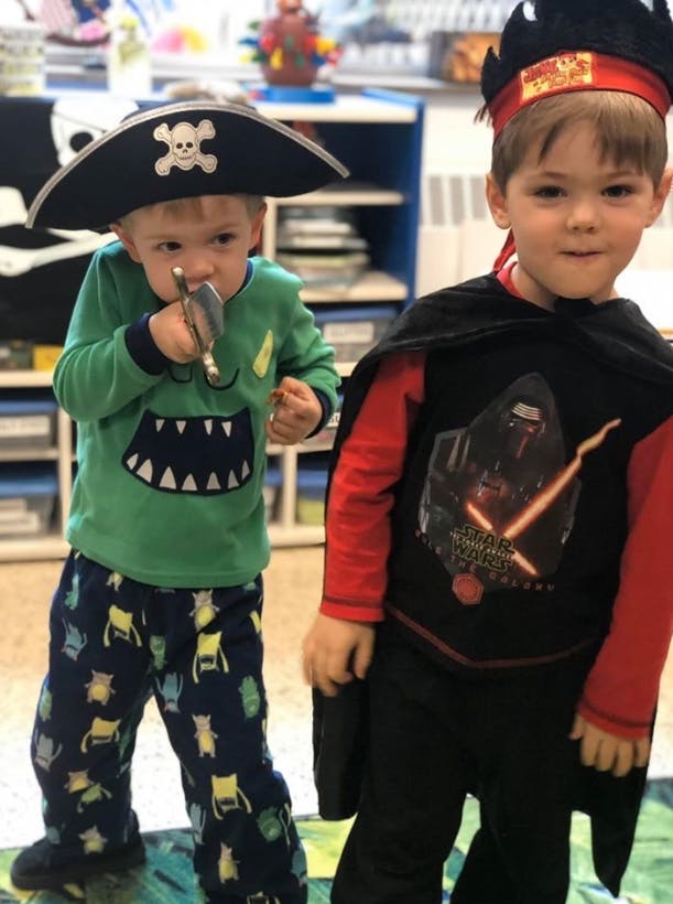 Two children in costumes, one in a pirate hat and the other in a cape