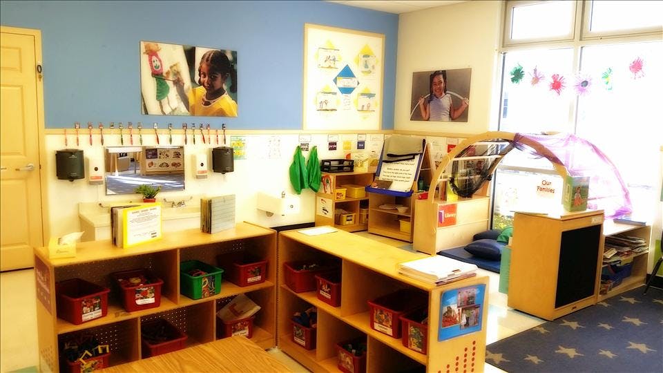 Classroom with child-height furniture, cubbies, sink, mirror, and learning materials