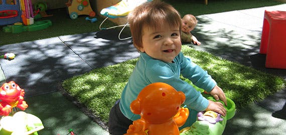 Child playing with toys on a green mat