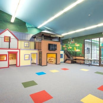 Indoor play area with a playhouse and colorful floor squares