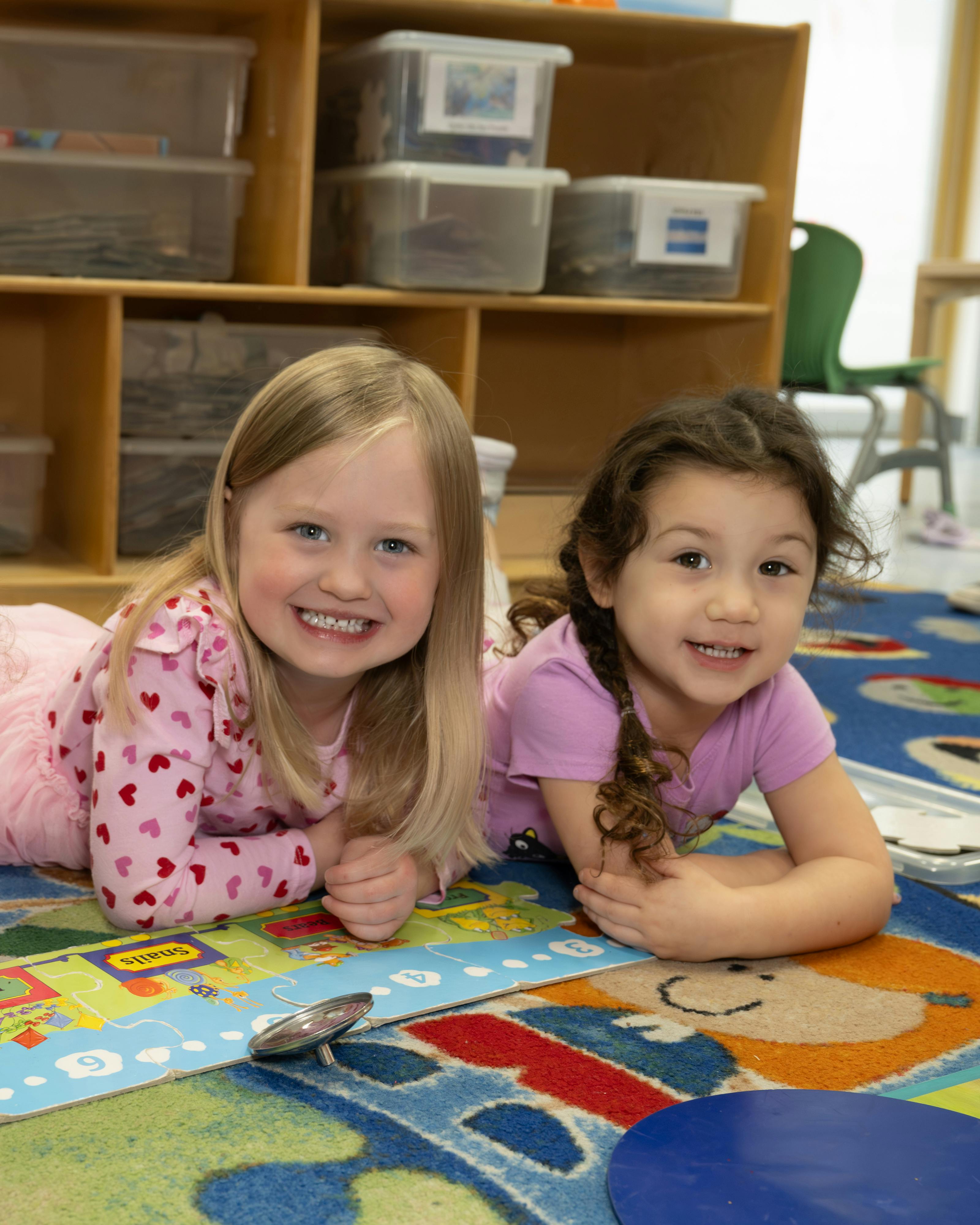 Two children lying on a colorful rug
