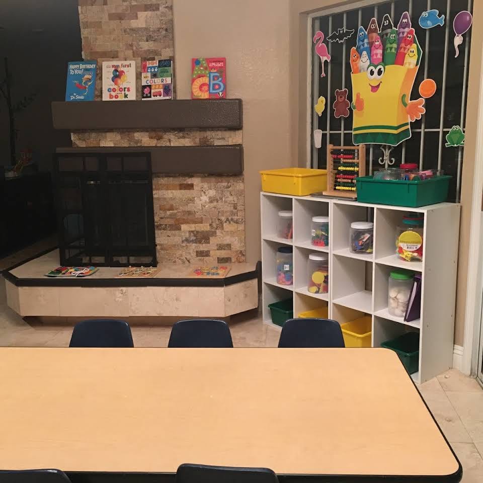 Classroom with a table, chairs, fireplace, and storage shelves