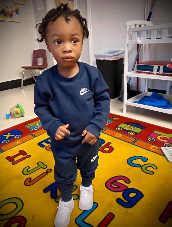Child standing on an alphabet rug