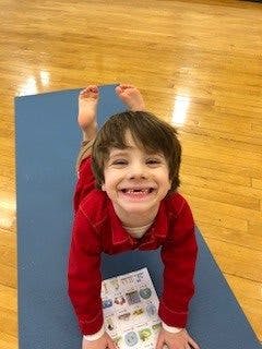 Child on a yoga mat in a cobra pose