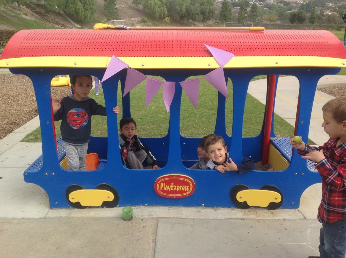 Children playing in a train-shaped play structure