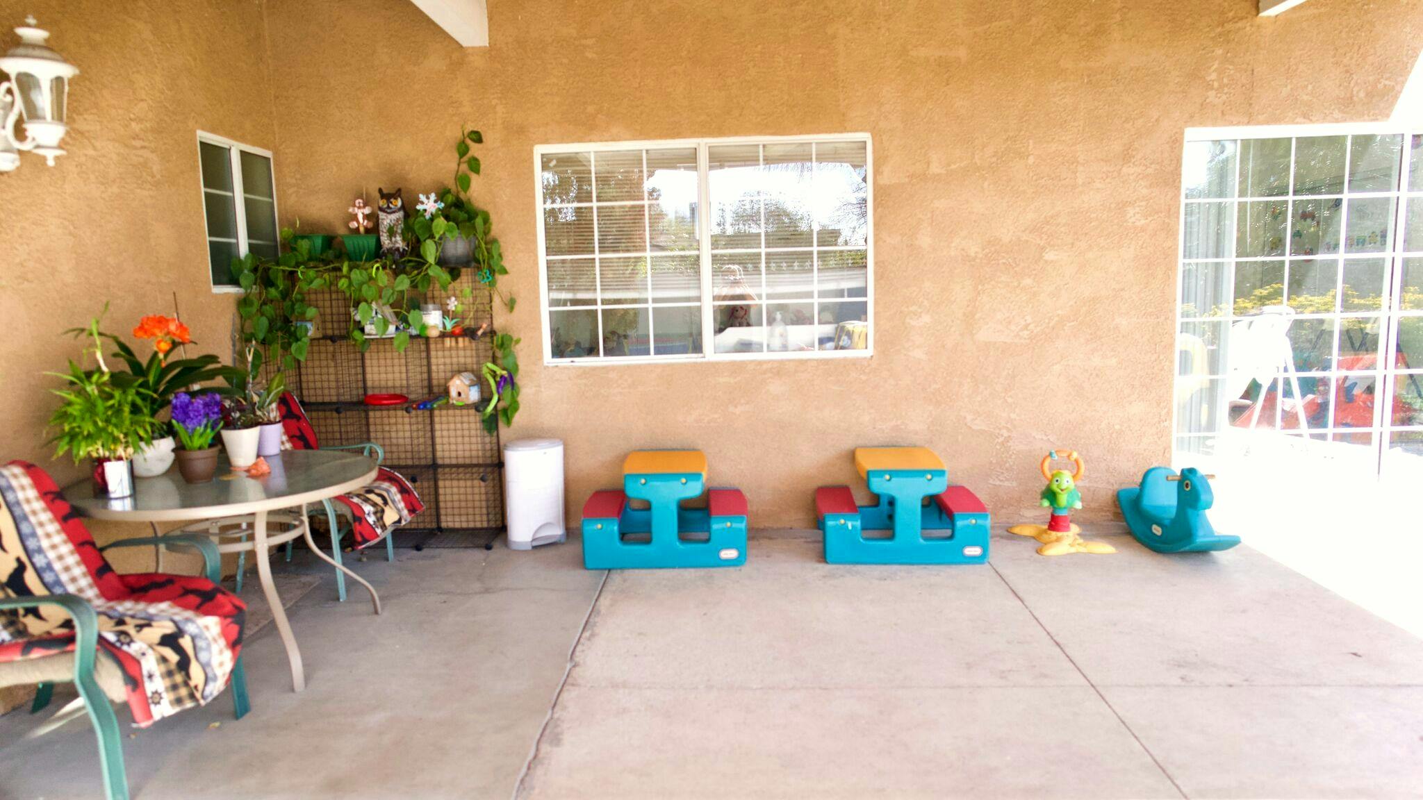 Covered patio with small picnic tables and toys