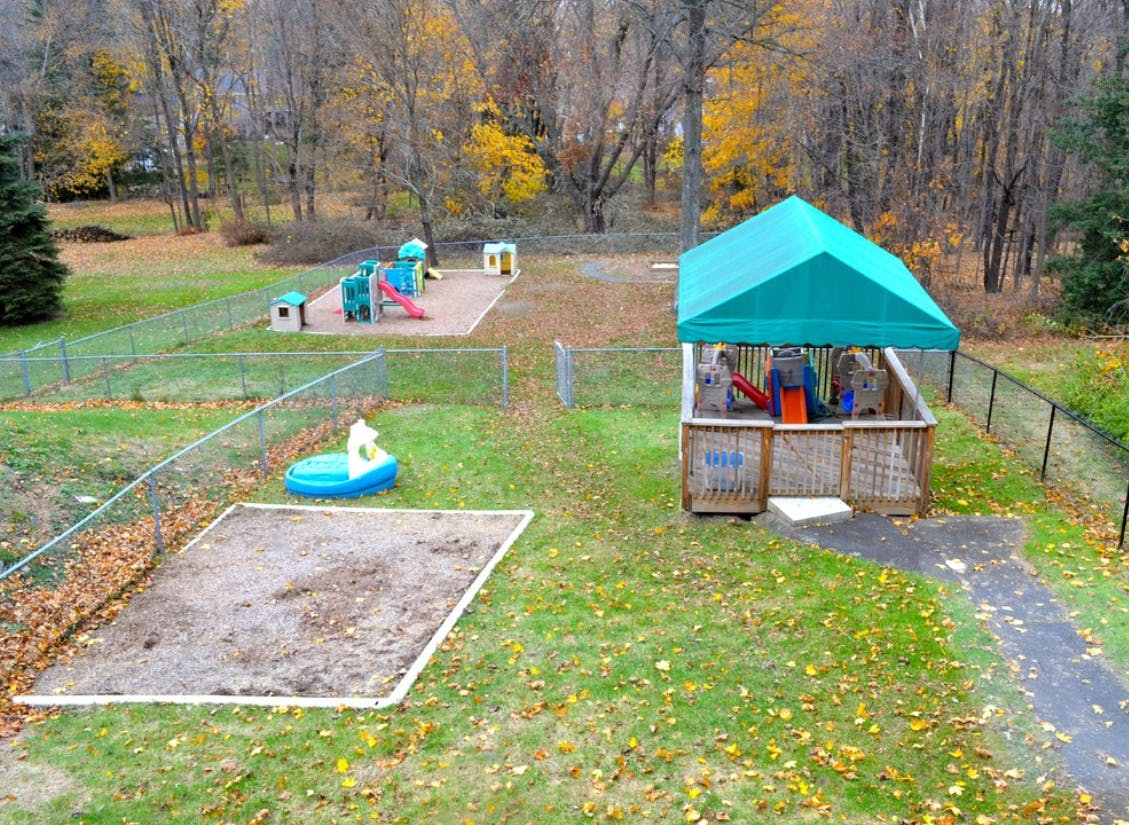 Outdoor playground with sandboxes, play structures, and a covered area