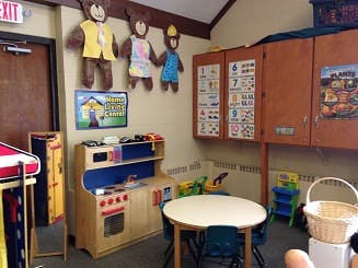 Play kitchen and small table with chairs in a classroom