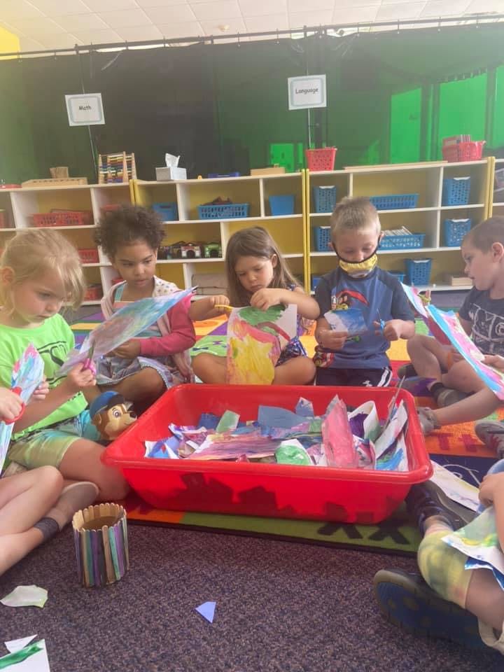Children sitting on the floor doing crafts in-class art activities