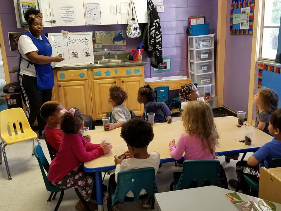 Person teaching a group of children in a classroom