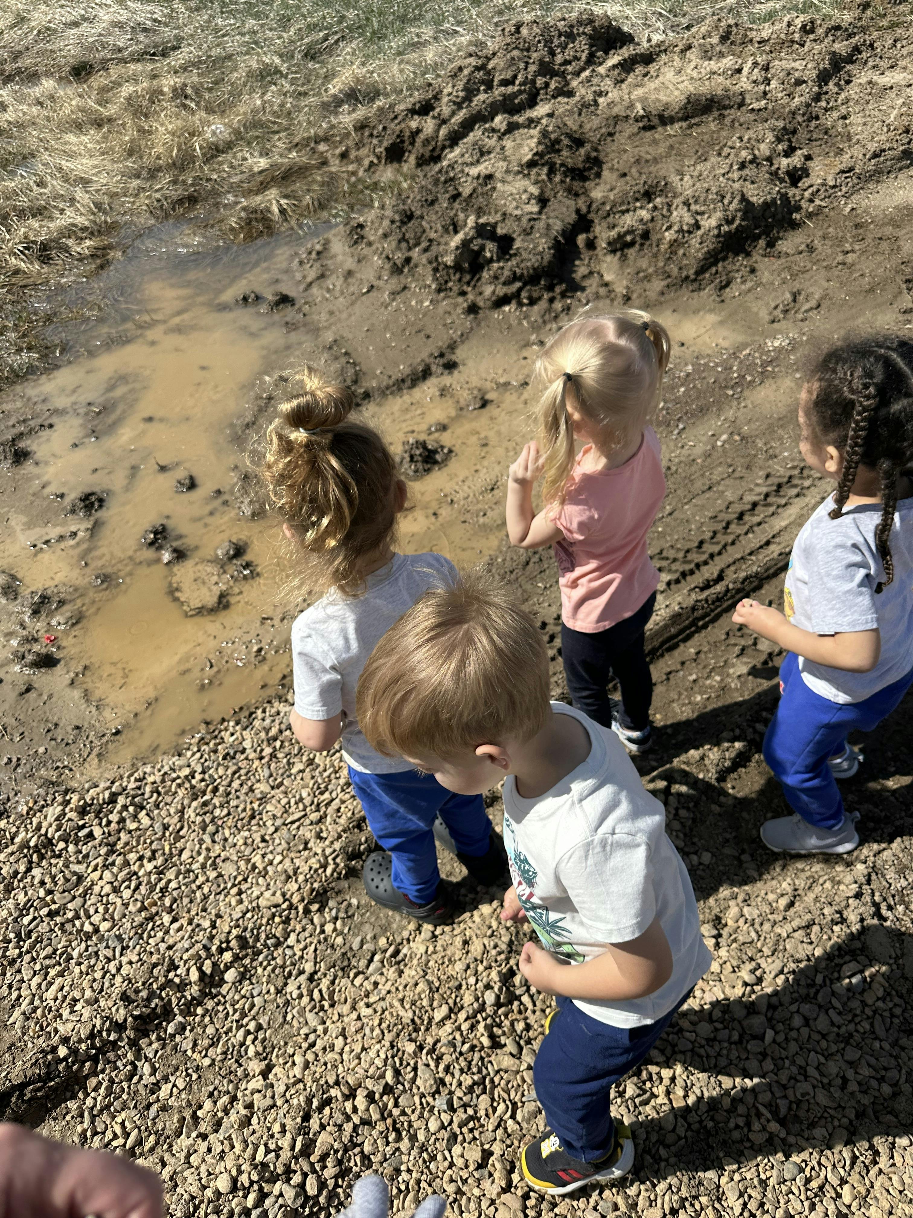 Children looking at a muddy puddle