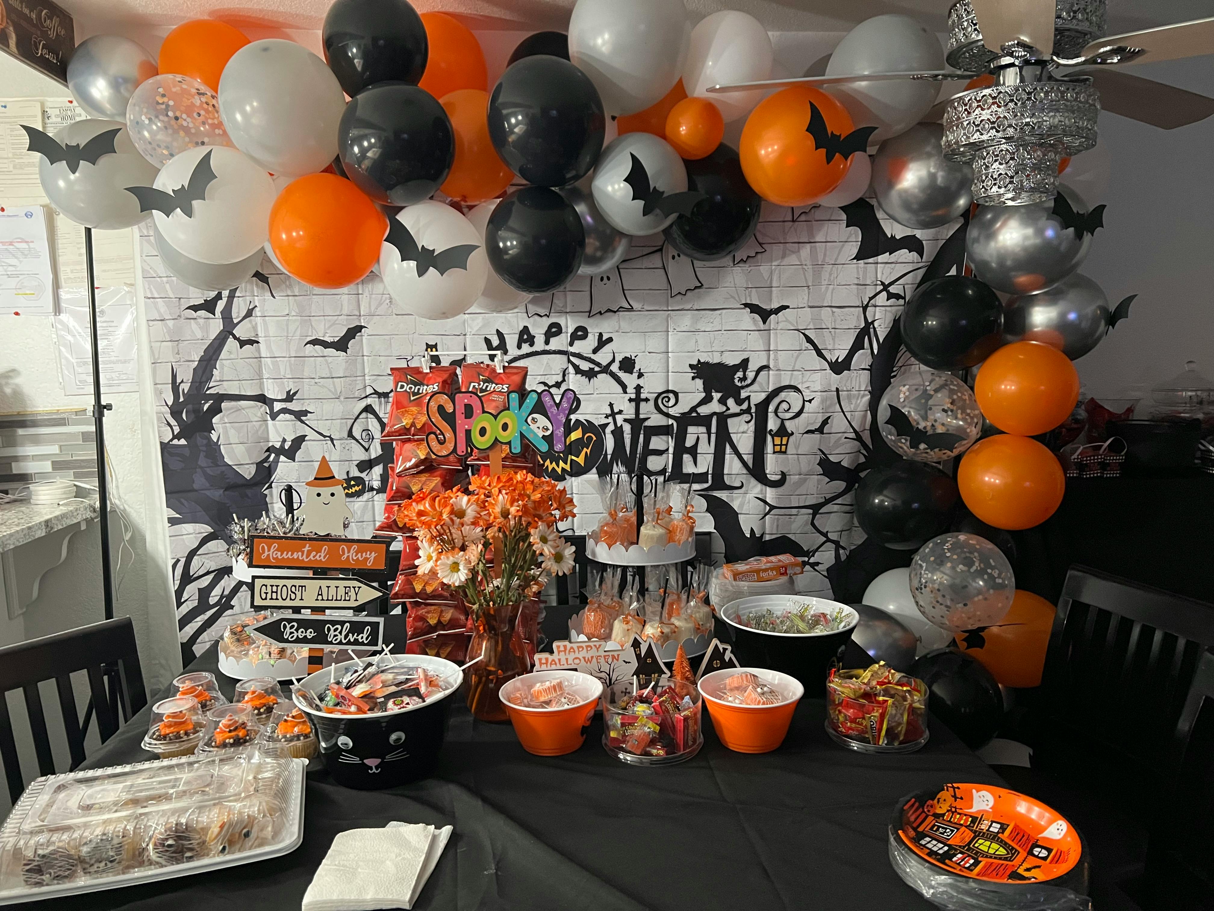 Table set with Halloween decorations, balloons, and party food