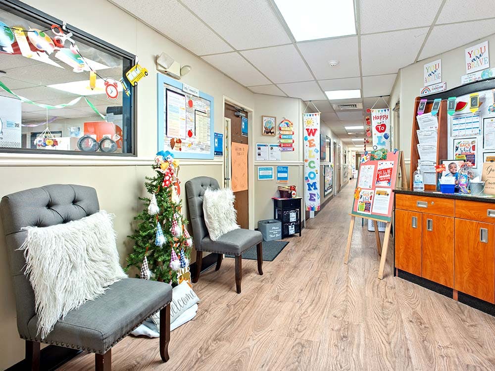 Hallway decorated with a small Christmas tree, chairs, and bulletin boards