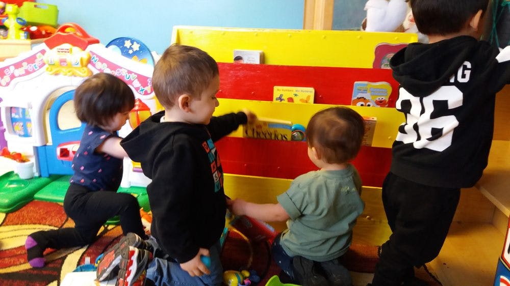 Children playing with toys and books in a classroom