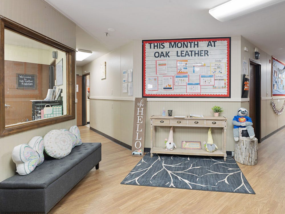 Hallway with a bench, a bulletin board, a wooden table, and a stuffed sloth