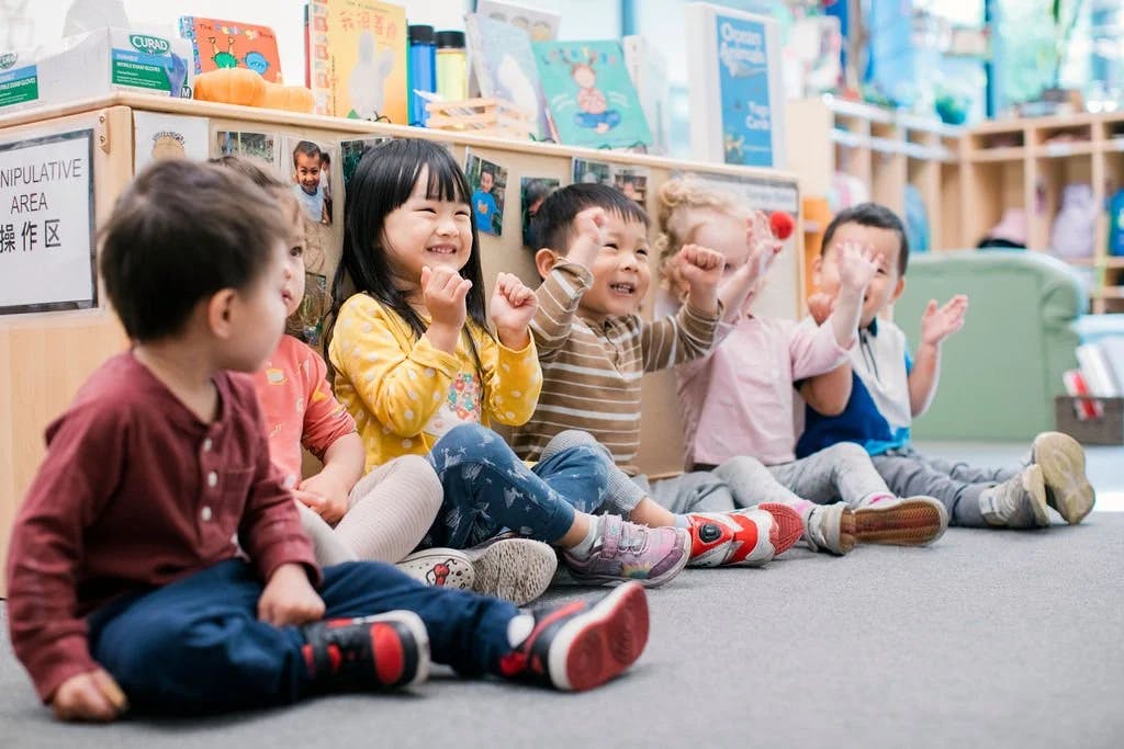 Group of young children sitting on the floor in a classroom