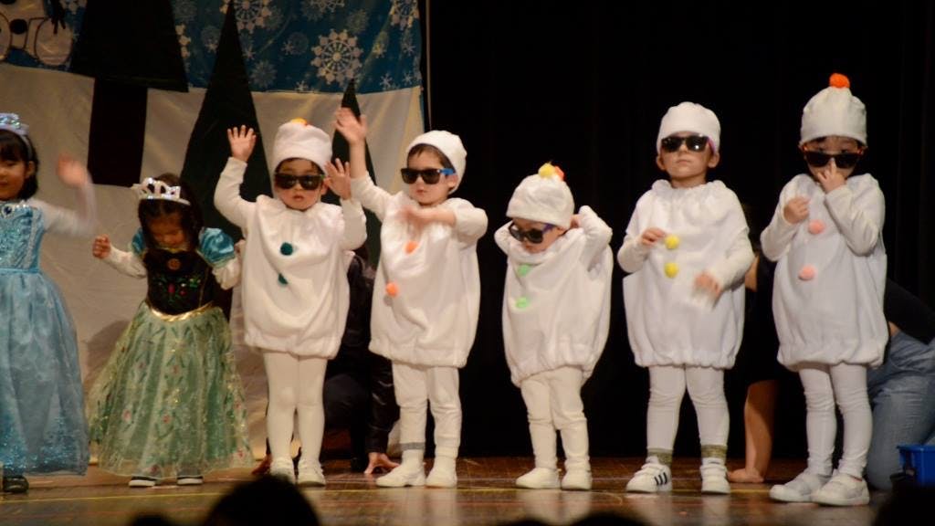 Children in costumes performing on a stage