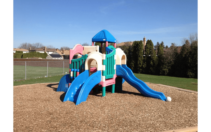 Colorful playground structure with multiple slides on wood chips
