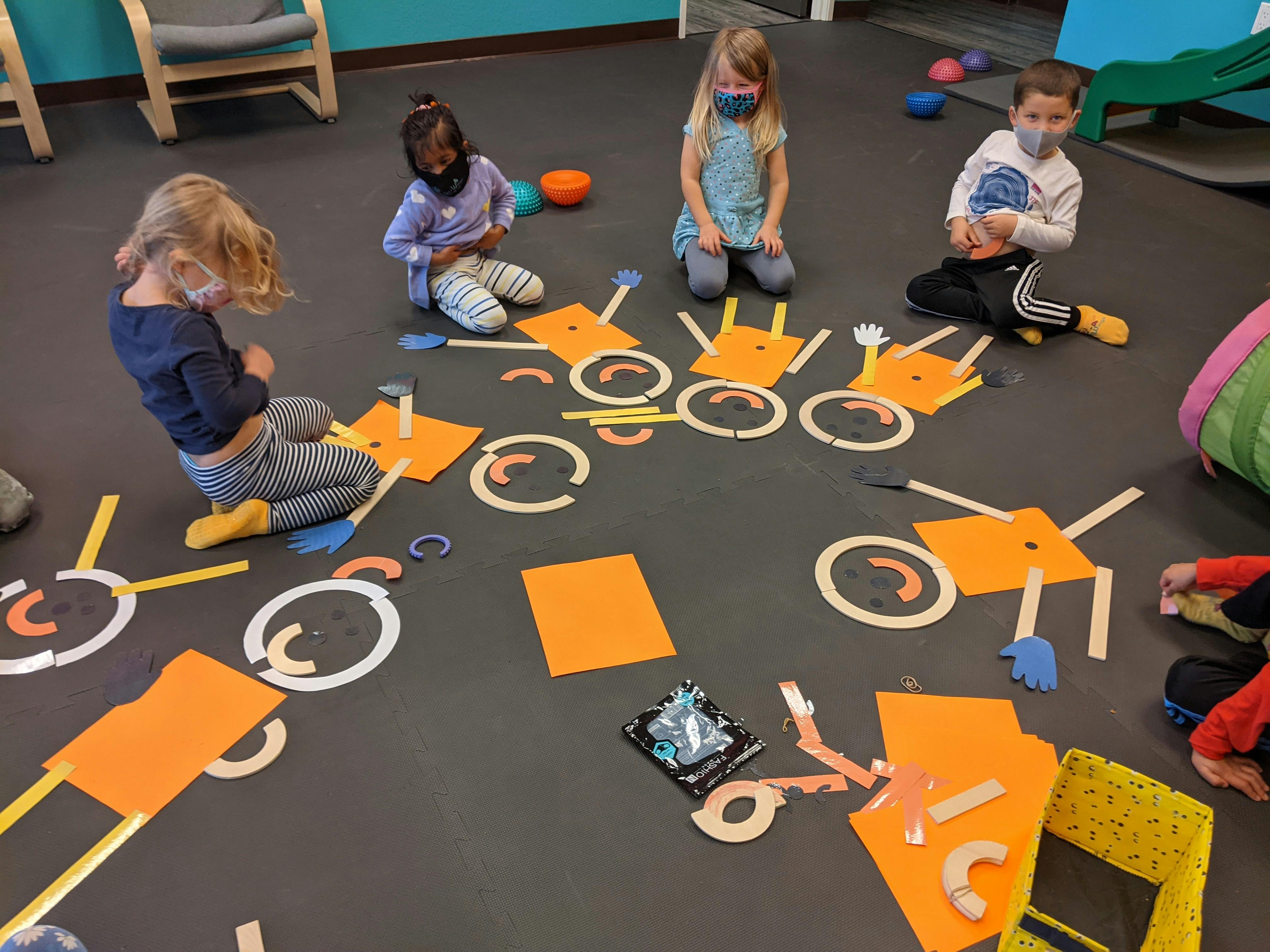 Children on floor playing with craft materials