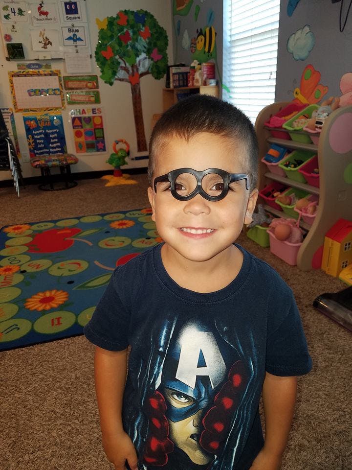 Child wearing novelty glasses in a classroom