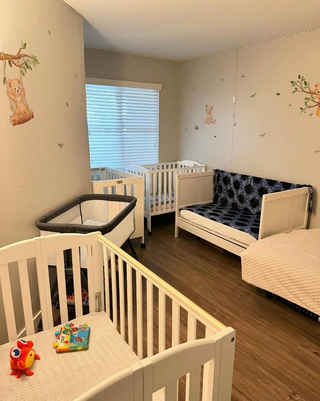 Room with multiple cribs and a small bed