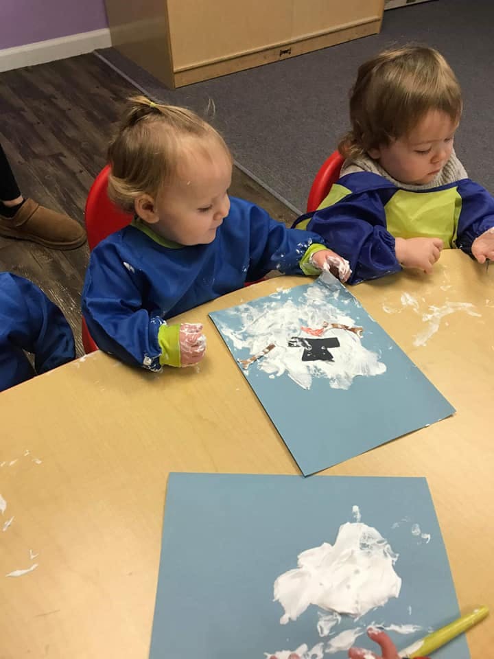 Two children painting at a table