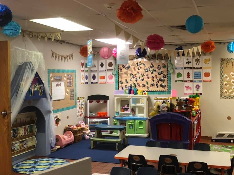 Playroom with a tent, play kitchen, and tables