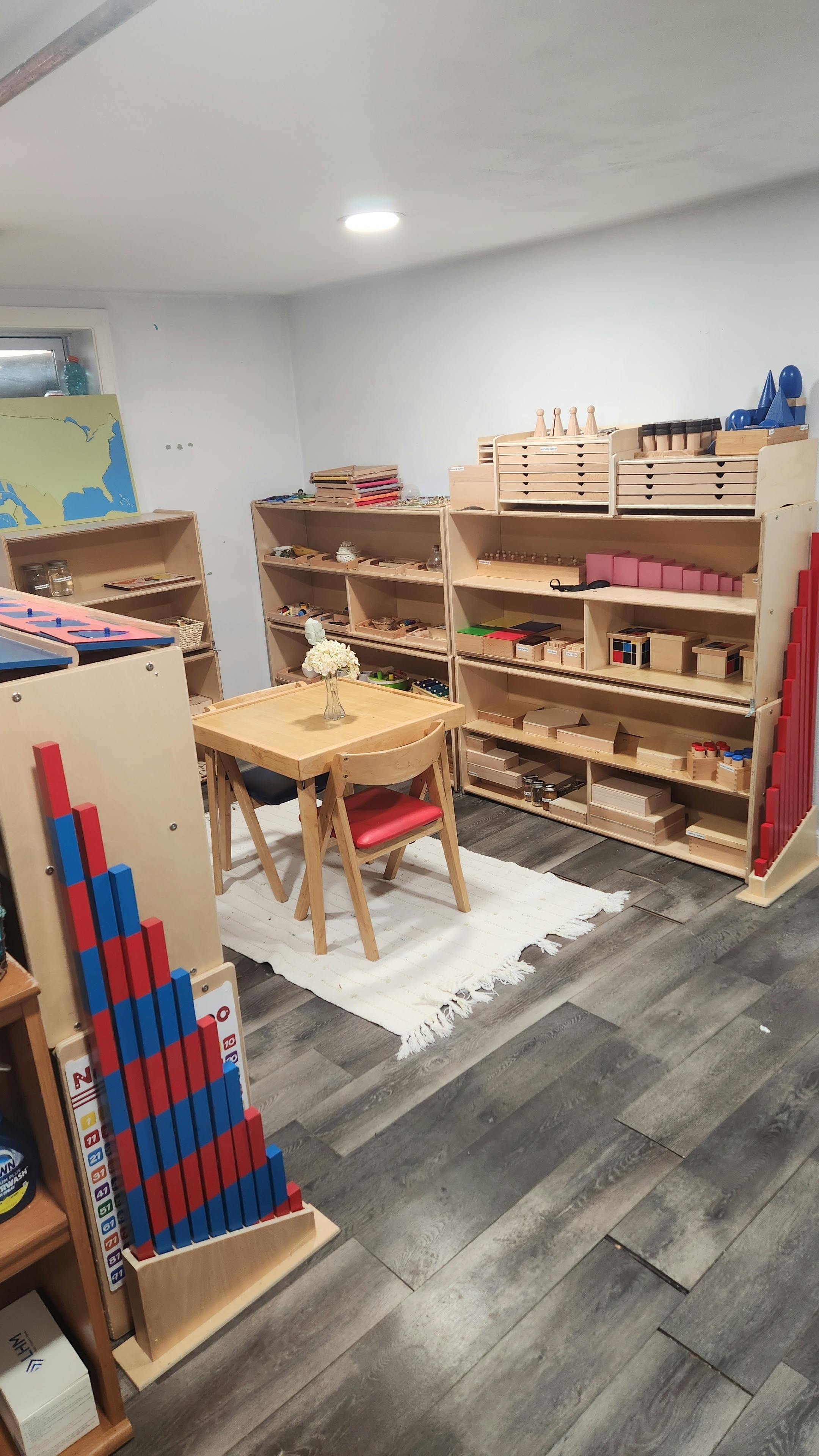 Classroom with shelves of learning materials and a small table with chairs