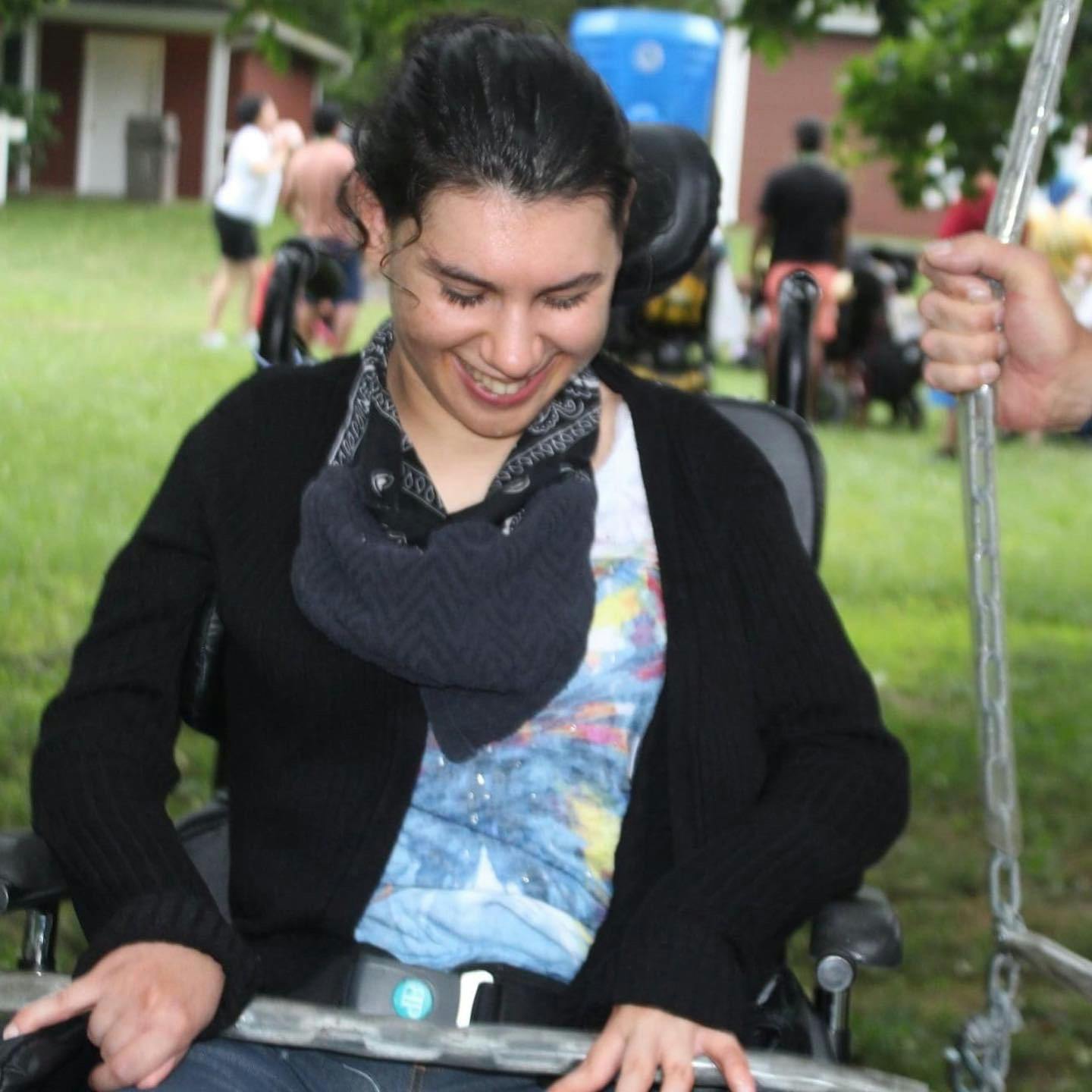Person in a wheelchair looking down and smiling