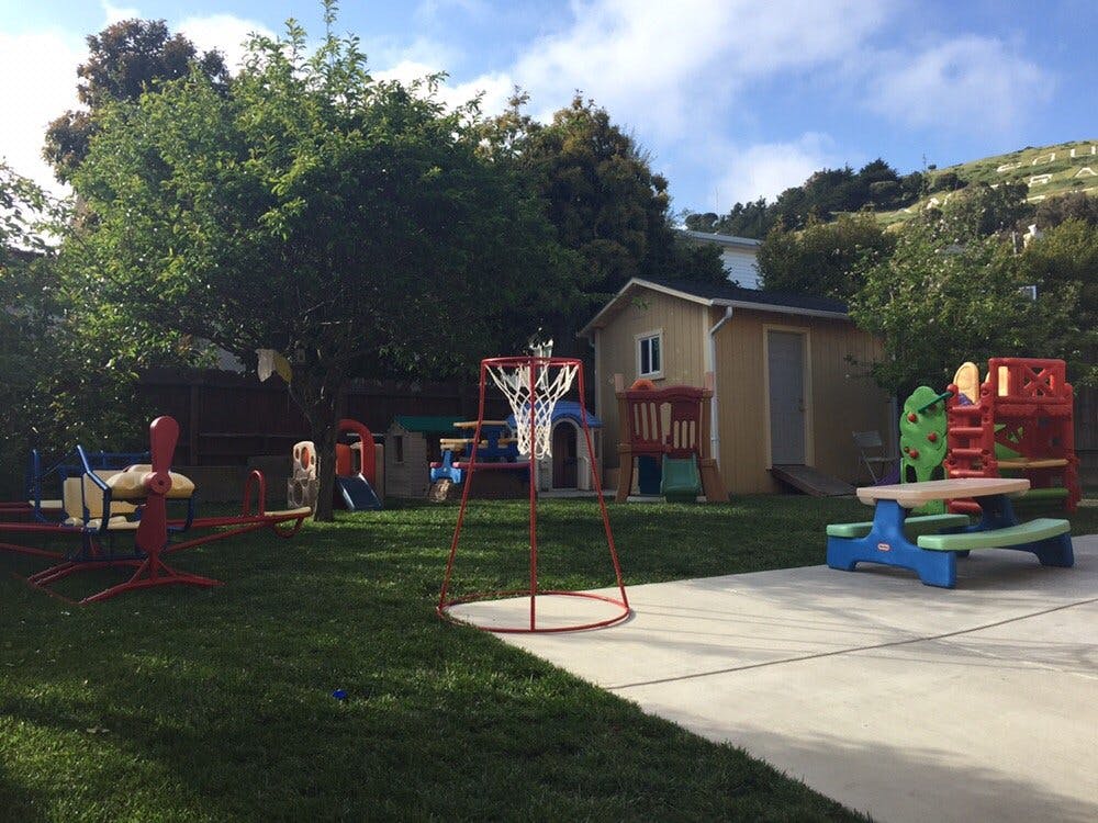Backyard with a basketball hoop, play structures, and a picnic table