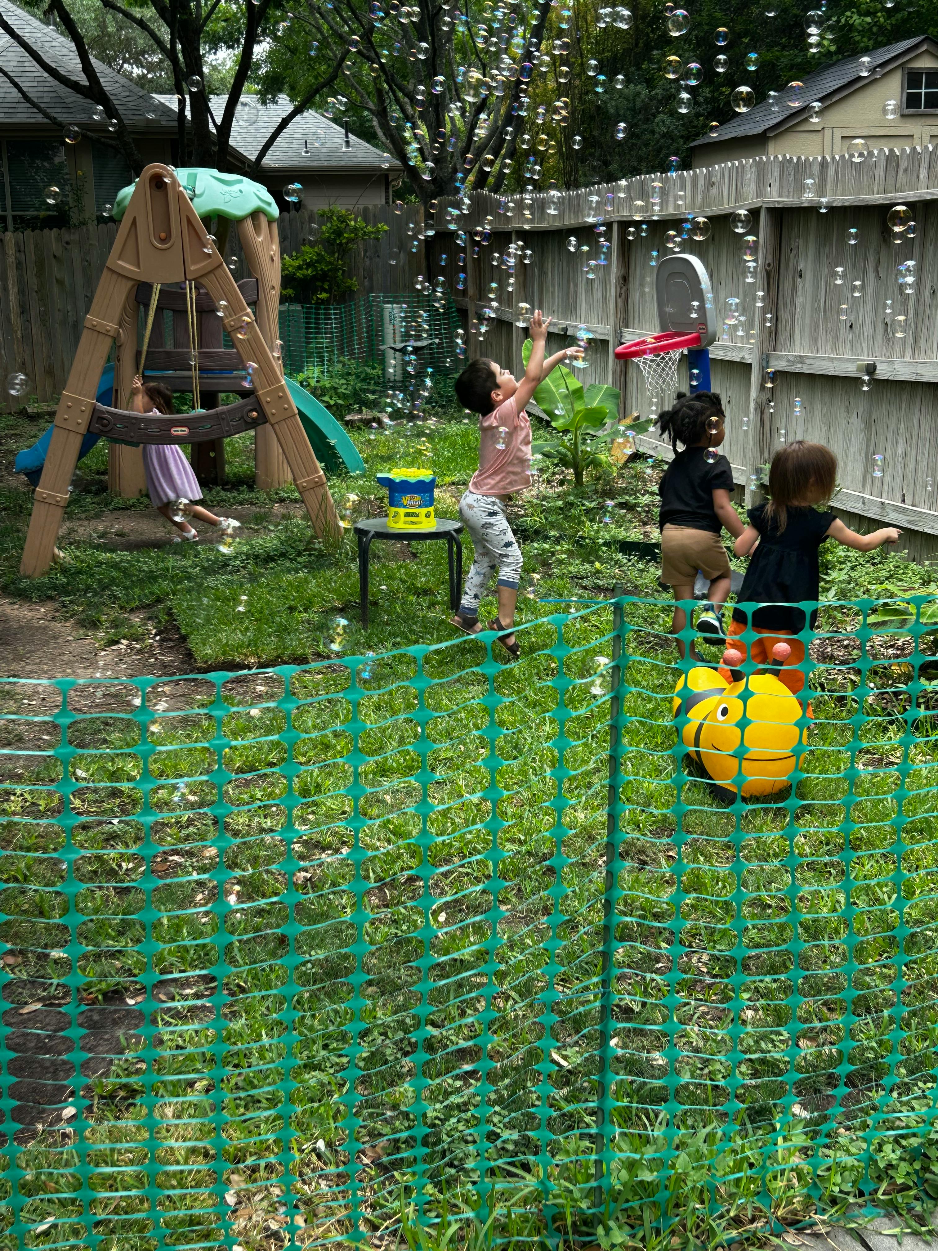 Children playing with bubbles in a backyard