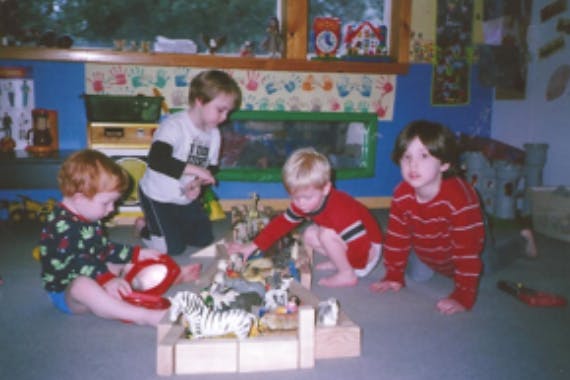 Four children playing with toys on the floor