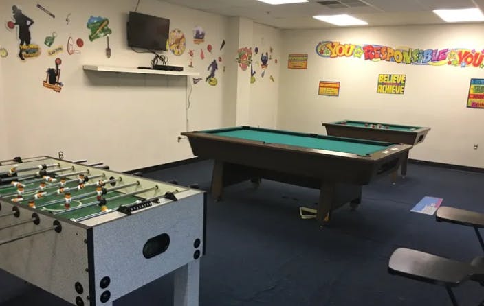 Foosball table and two pool tables in a room