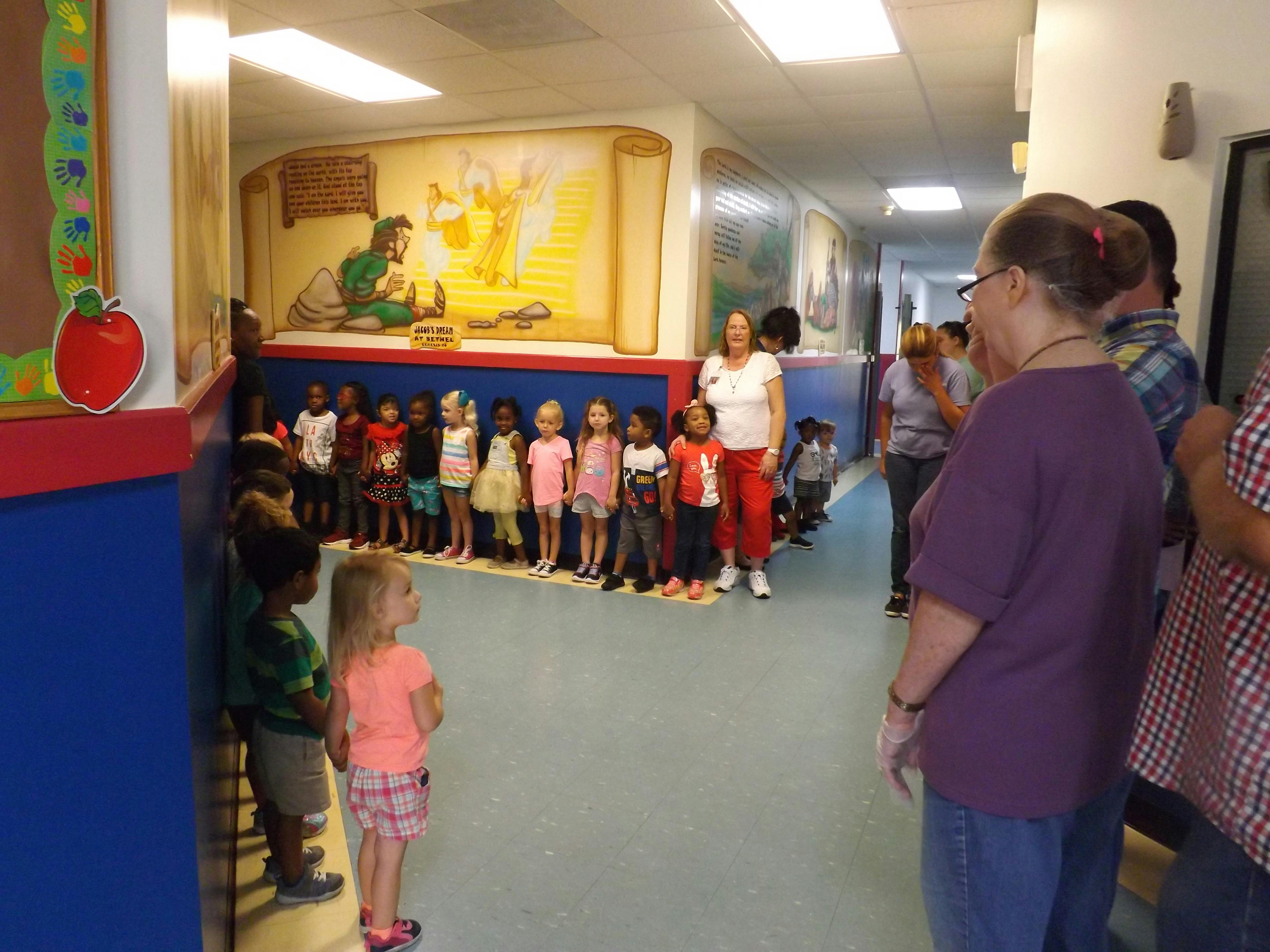 Adults and children standing in a hallway