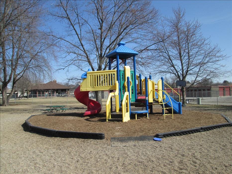 Colorful playground structure with slides and steps on wood chips