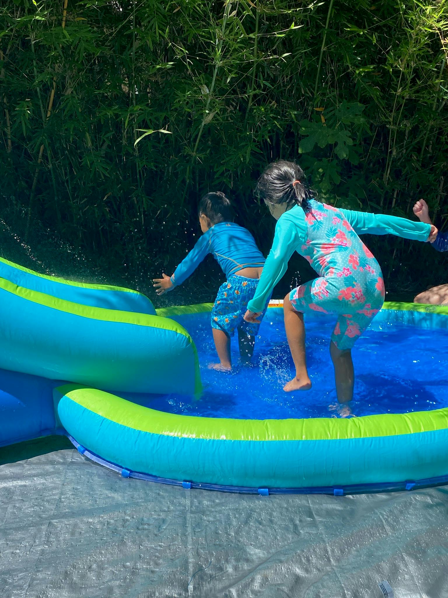 Two children playing in an inflatable pool