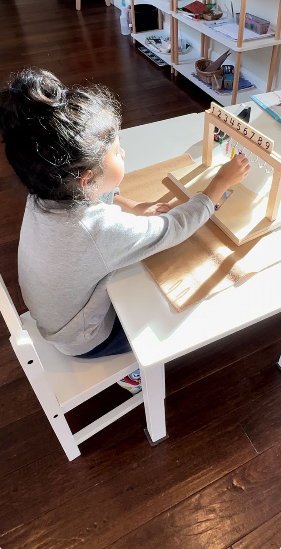Child at a table working with a number counting frame