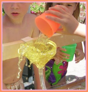 Child pouring liquid into a funnel