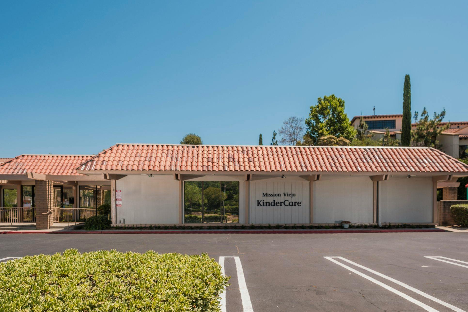 Building with terra cotta roof tiles and "Mission Viejo KinderCare" on the sign