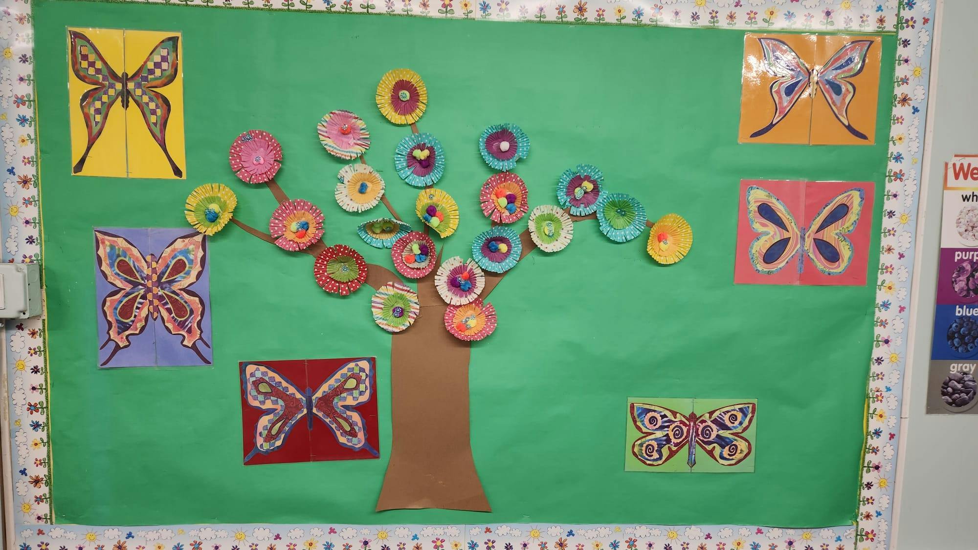 Bulletin board with a tree and butterfly cutouts