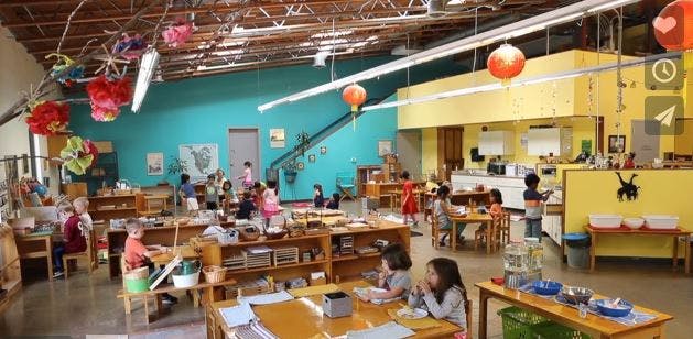 Children in a classroom with tables and learning materials