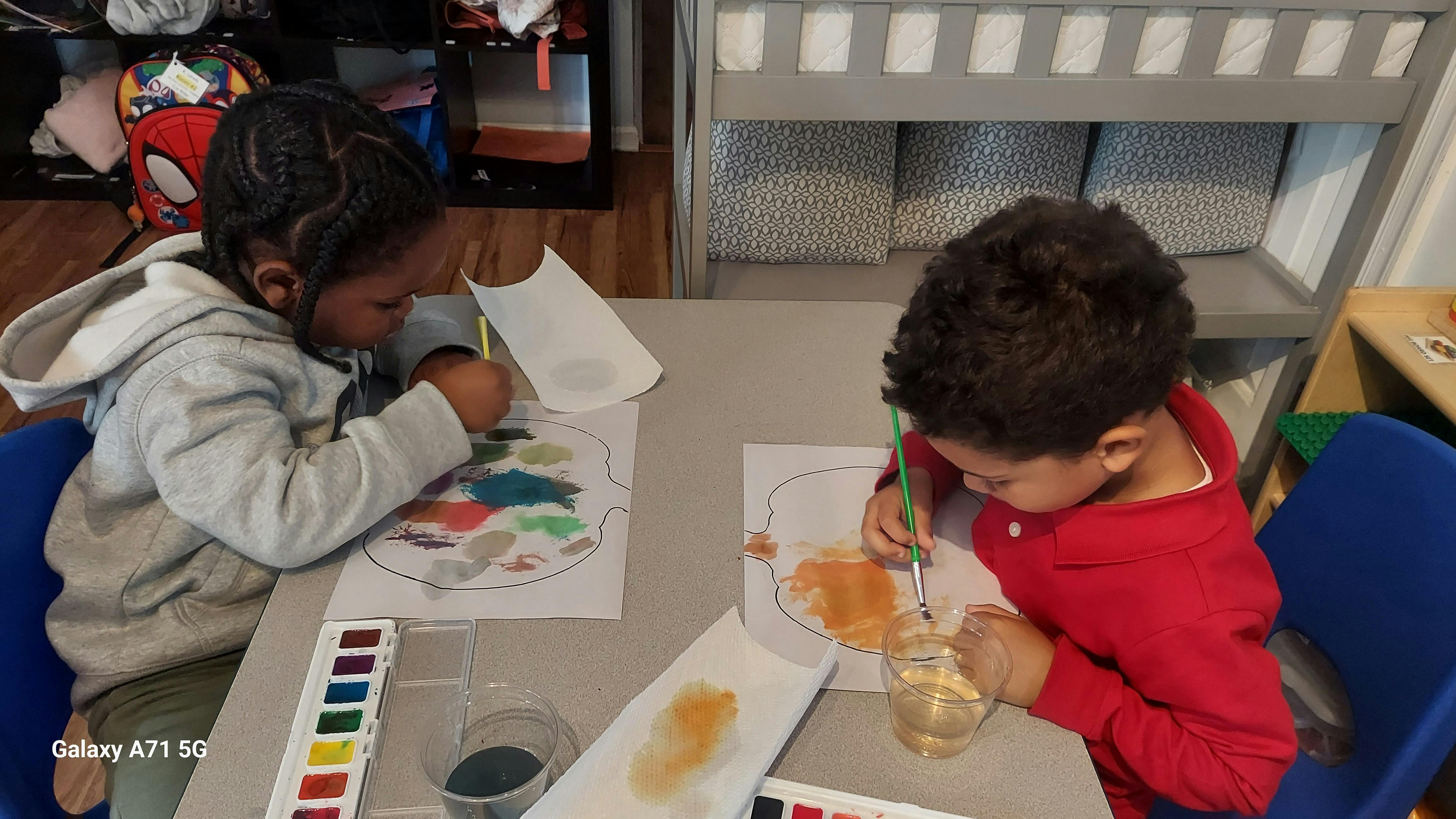 Two children painting at a table