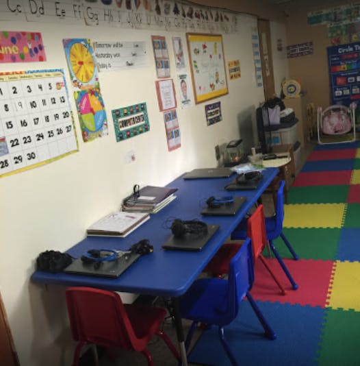 Classroom with a long blue table and colorful chairs