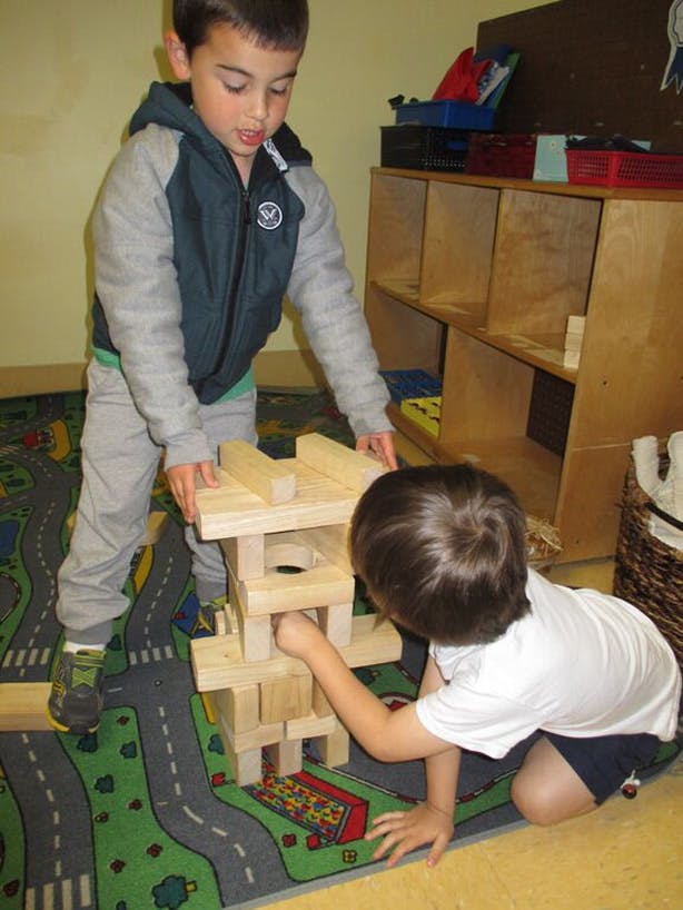Two children building with wooden blocks