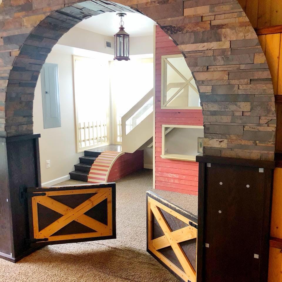 Stone archway with two half-doors opening to a room with stairs and a ramp