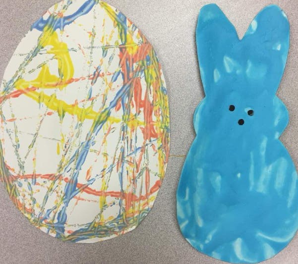Paper egg with paint splatters and a blue paper bunny